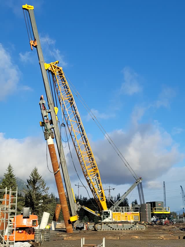 Lattice-boom crane with fixed leads driving piles