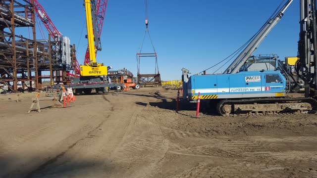 Crawler crane and piling spread working alongside module steel at an industrial facility