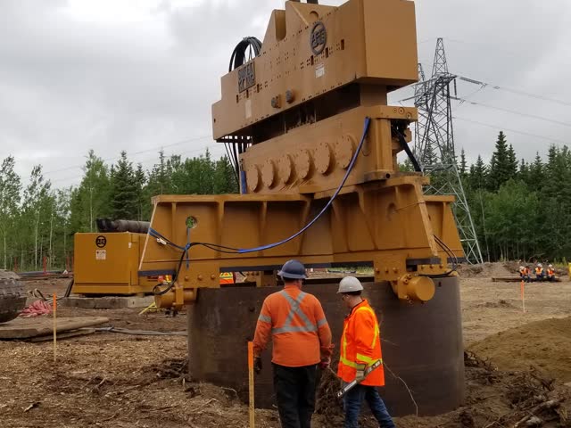 Crew guiding a hammer head onto a large-diameter casing