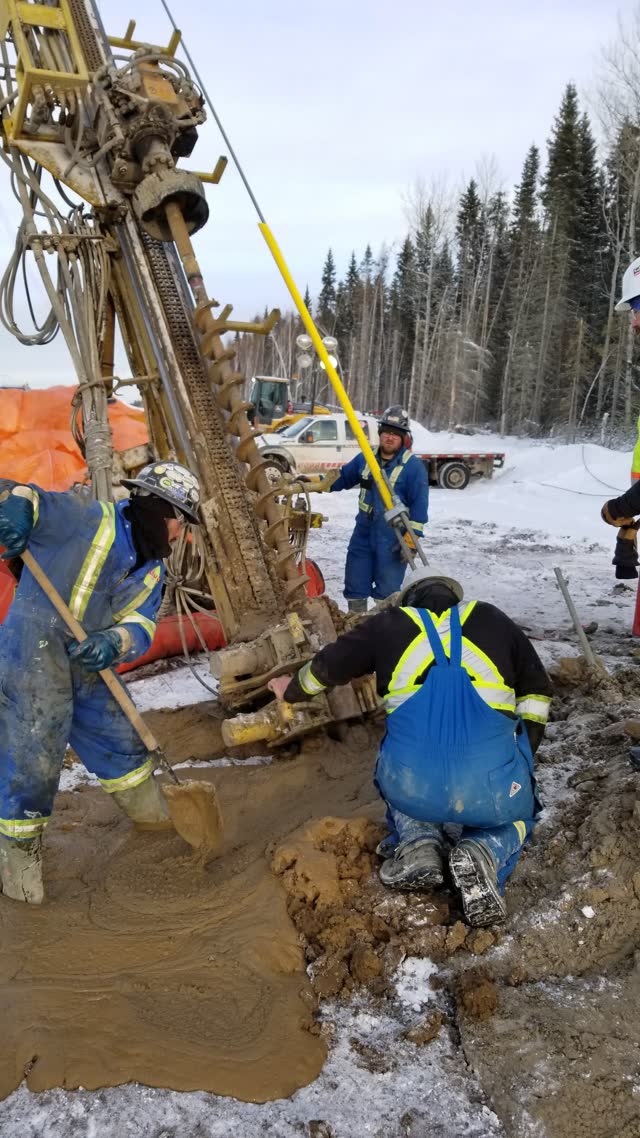 Crew grouting a drilled foundation in winter conditions
