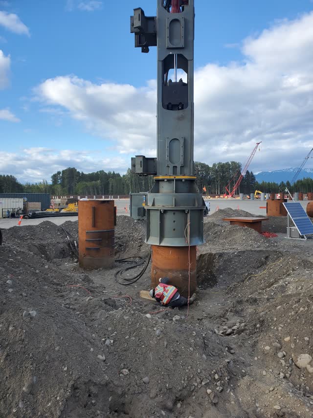 Hydraulic hammer seated on a steel casing during pile installation