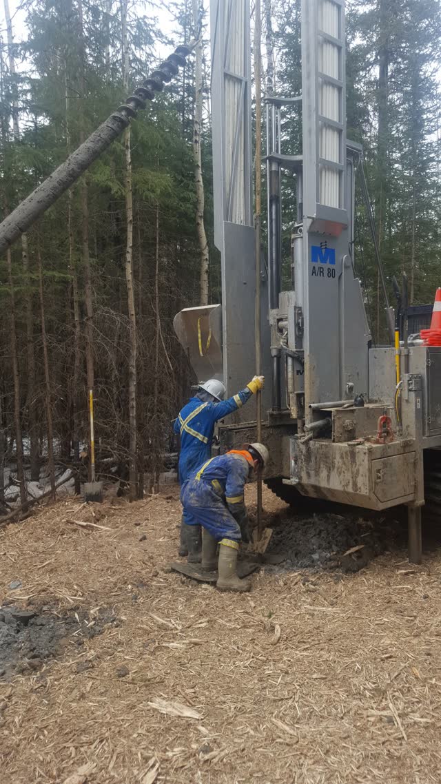 Drill rig and operator installing a foundation shaft on a forested right-of-way