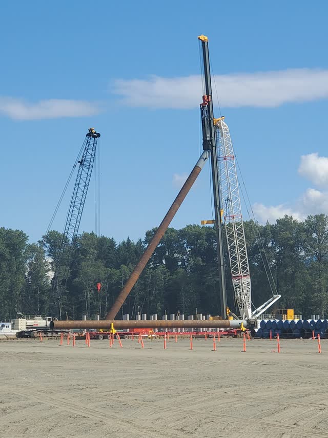 Lattice crane rig positioned on a riverbank foundation location